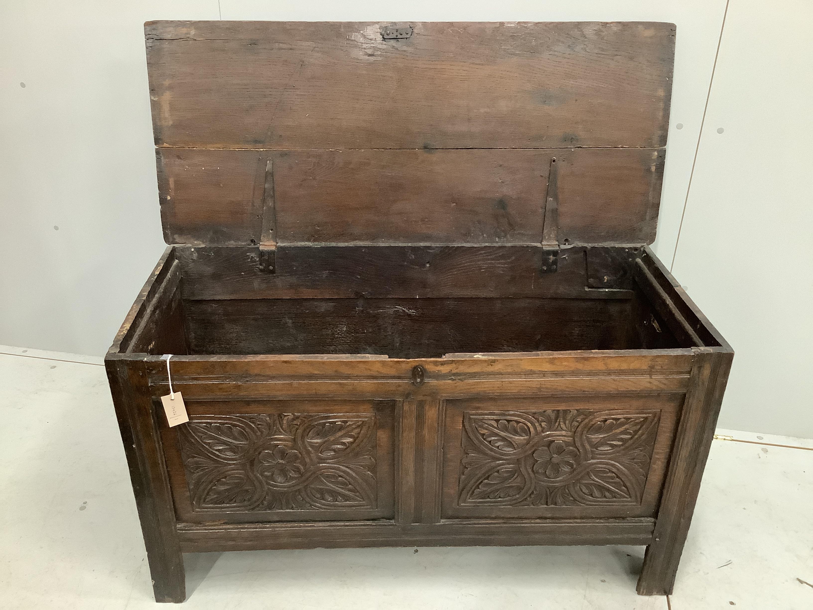 An 18th century carved panelled oak coffer, width 120cm, depth 51cm, height 67cm